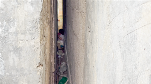 2岁女娃撵狗卡进15厘米墙缝 哭累了喝奶哄自己