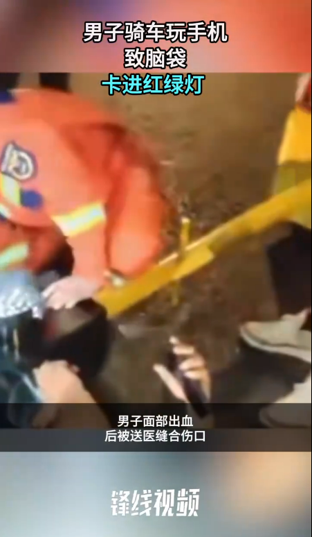 一男子边骑车边玩手机撞上灯柱 导致脑袋卡进红绿灯